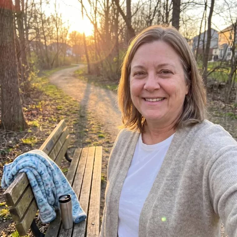 Woman resting on a park bench during an evening walk